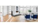 Bright, open-concept living room featuring hardwood floors, fireplace, and ample natural light from large windows at 6251 N Galena St, Denver, CO 80238