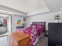 Well-lit bedroom features a comfortable bed, vibrant decor, and access to a private balcony at 14439 E 1St Dr # C11, Aurora, CO 80011