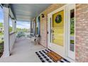 Inviting front porch with brick accents, white pillars, and a 'Welcome Home' doormat at 9954 Heywood St, Highlands Ranch, CO 80130