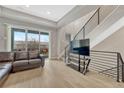 Spacious living room with a black metal staircase, hardwood floors, and access to an outdoor balcony at 7881 W 51St Ave # B, Arvada, CO 80002