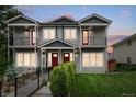 Charming two-story townhouse features gray siding, red doors, inviting balconies, and professionally maintained landscaping at 4730 S Acoma St, Englewood, CO 80110