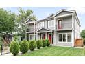 Inviting two-story townhouse showcases gray siding, red doors, charming balconies, and lush, landscaped front yard at 4730 S Acoma St, Englewood, CO 80110