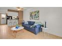 Cozy living room featuring stylish decor, a blue sofa, and hardwood floors at 6742 S Independence St, Littleton, CO 80128