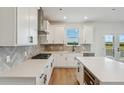 Bright kitchen features white cabinets, quartz countertops, stainless steel appliances, and a stylish backsplash at 5439 Westin Hills Dr, Elizabeth, CO 80107