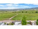 Stunning aerial view of a home with beautiful green space and lake views in the background at 8544 S Upham Way, Littleton, CO 80128