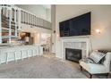 Open-concept living area features a fireplace, spiral staircase, and breakfast bar leading to the kitchen at 10872 W Evans Ave # 3D, Lakewood, CO 80227
