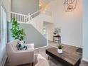 Inviting living room showcasing high ceilings, a modern chandelier, and staircase access to the upper level at 12653 Jersey E Cir, Thornton, CO 80602