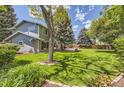 Beautiful backyard with expansive lawn, mature trees, and a cozy patio area perfect for outdoor entertaining at 6338 S Oneida Ct, Centennial, CO 80111