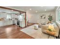Open-concept living space with hardwood floors, a modern kitchen, and comfortable seating at 2598 Teller St, Lakewood, CO 80214