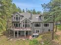 Rear exterior showing large windows, hot tub, two-story deck and manicured lawn at 29433 Firethorne Ct, Evergreen, CO 80439
