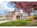 Inviting two-story home featuring stone accents, well-manicured lawn and a beautiful blooming tree at 7407 E Long Cir, Centennial, CO 80112