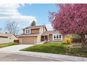 Inviting home featuring stone accents, well-manicured lawn and a beautiful blooming tree in the front yard at 7407 E Long Cir, Centennial, CO 80112
