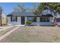 Charming single-story home with updated gray roof, white painted brick, and walkway path at 1675 N Wabash St, Denver, CO 80220