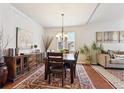 Elegant dining room with hardwood floors, stylish chandelier, and ample space for entertaining guests at 24714 E Quarto Pl, Aurora, CO 80016