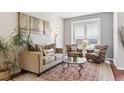 Cozy living room featuring neutral tones, a decorative rug, and plenty of seating for relaxation at 24714 E Quarto Pl, Aurora, CO 80016