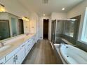 Contemporary bathroom with double vanity, a soaking tub, and a glass-enclosed shower at 229 Wooten Ave, Brighton, CO 80601