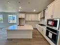 Modern kitchen featuring a large island, stainless steel appliances, and bright white cabinetry at 229 Wooten Ave, Brighton, CO 80601
