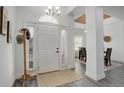 Bright foyer featuring a white door with sidelights, wood floors, and hat rack at 4270 Defoe St, Strasburg, CO 80136