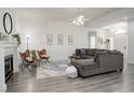 Spacious living room with a fireplace, comfortable seating, and hardwood floors at 4270 Defoe St, Strasburg, CO 80136