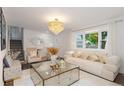 Bright living room featuring a large window, modern decor, and a glamorous chandelier at 5831 W 108Th Pl, Westminster, CO 80020