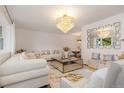 Spacious living room boasting stylish furniture, a mirrored coffee table, and elegant chandelier at 5831 W 108Th Pl, Westminster, CO 80020