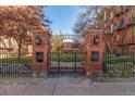 Welcoming gated entrance to a community with a beautifully landscaped central green space and classic brick architecture at 1376 N Pearl St # B1, Denver, CO 80203