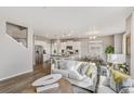 Open-concept living room connected to the dining area and kitchen with modern decor and lots of light at 4837 Cattle Cross Ln, Castle Rock, CO 80104