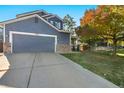 Well-maintained home featuring a spacious driveway and a two-car garage with stone accents at 1540 Meachum Way, Erie, CO 80516