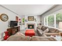 Comfortable living room featuring a fireplace, plush seating, and a large window that lets in ample natural light at 3317 Harlan St, Wheat Ridge, CO 80033