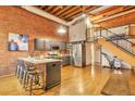 Open kitchen with stainless steel appliances and a spacious island with seating in a bright, open loft at 1143 Auraria Pkwy # 101, Denver, CO 80204