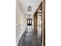 Hallway with dark hardwood floors, beams and visible front door at 1214 S Fillmore St, Denver, CO 80210