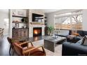 Inviting living room featuring a stone fireplace, dark wood floors and an abundance of natural light at 1214 S Fillmore St, Denver, CO 80210
