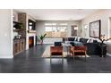 Bright living room with a cozy fireplace, large windows, stylish furniture, and dark hardwood flooring at 1214 S Fillmore St, Denver, CO 80210