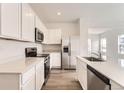 Modern kitchen with stainless steel appliances, quartz countertops, and ample cabinet space at 15261 Fillmore St, Thornton, CO 80602