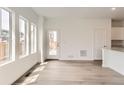 Bright living room featuring natural light, light wood flooring, and access to the outdoor deck at 15261 Fillmore St, Thornton, CO 80602