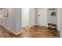 Hallway with wood floors, white doors, coat rack, and bench at 909 N Logan St # 1B, Denver, CO 80203