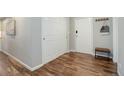 Hallway with wood floors, white doors, coat rack, and bench at 909 N Logan St # 1B, Denver, CO 80203