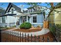 Charming home with well-maintained landscaping, stone pathway, and black metal fence at 161 W Maple Ave, Denver, CO 80223