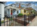A charming home with a manicured front yard and a black metal fence along the sidewalk at 161 W Maple Ave, Denver, CO 80223