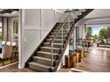 Elegant staircase featuring wood treads, glass railings, and modern design elements at 6289 Cristobal Pt, Parker, CO 80134