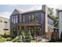 Contemporary home showcasing a blend of brick and wood siding, complemented by professionally landscaped greenery at 1130 S Cook St, Denver, CO 80210