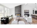 Bright living room featuring a modern fireplace, hardwood floors, and stylish contemporary furnishings at 11825 W 25Th Ave, Lakewood, CO 80215