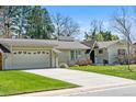 Charming single-story home boasts a well-manicured lawn and convenient attached garage and a long driveway at 3844 S Elm St, Denver, CO 80237