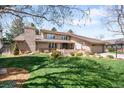 Beautiful two-story home with a well-manicured lawn, mature trees, and a brick chimney at 4833 E Links Cir, Centennial, CO 80122