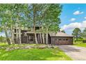 Two-story home with brown wood siding, attached garage, and surrounding aspen trees at 1927 Sunset Cir, Evergreen, CO 80439