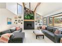 Bright living room with high ceilings, wood beams, fireplace, and gray couches at 1927 Sunset Cir, Evergreen, CO 80439