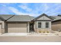 Charming single-story home featuring stone accents, a well-maintained lawn, and a two-car garage at 11791 Barrentine Loop, Parker, CO 80138