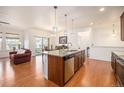 Bright open kitchen boasts a large island with granite countertops and stainless steel appliances at 11791 Barrentine Loop, Parker, CO 80138