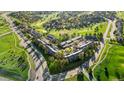 Aerial view of a townhouse community nestled among mature trees and a well-maintained golf course at 6519 Pinewood Dr, Parker, CO 80134