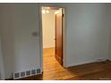 Hallway with hardwood floors and white walls leads to a room with a ceiling fan at 5899 Vance St, Arvada, CO 80003